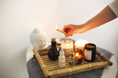 Close-up of hand holding candles on table