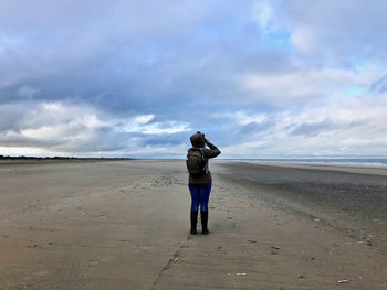 Full length rear view of man standing on beach