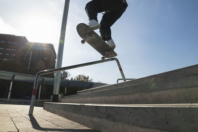 Man skateboarding on railing at skateboard park