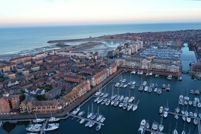 High angle view of buildings by sea against sky