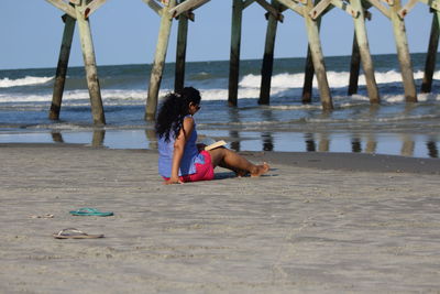 Full length of woman sitting on beach