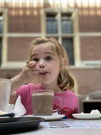 Young woman drinking chocolate milk in cafe