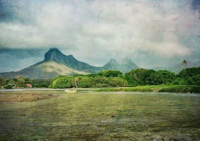 Scenic view of mountains against cloudy sky