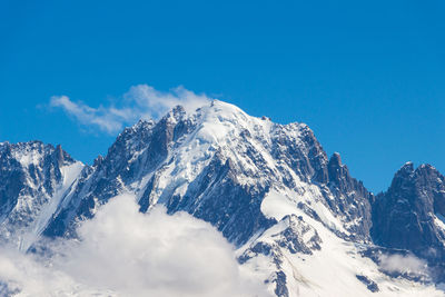 Scenic view of snowcapped mountains against blue sky