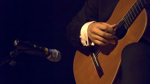 Midsection of musician playing guitar