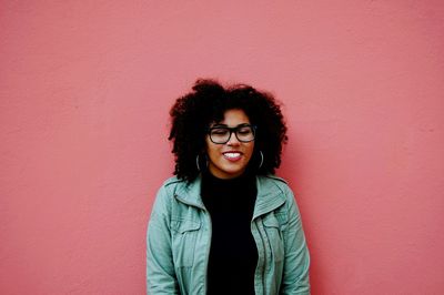 Woman with curly hair standing against wall