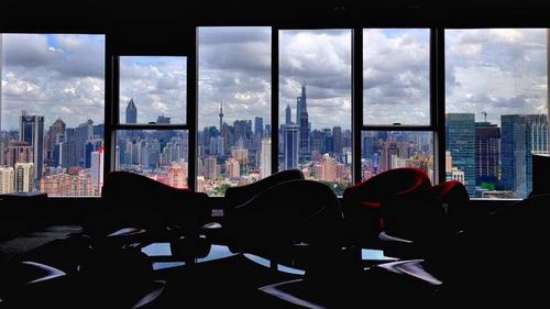 View of cityscape against cloudy sky