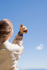 Caucasian woman smiling holding small dog yorkshire terrier. woman travel with pet, looking at view