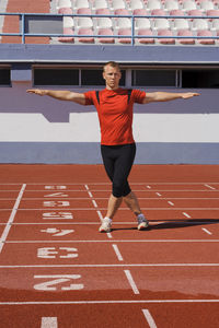 Man stretching on running track, algarve, portugal