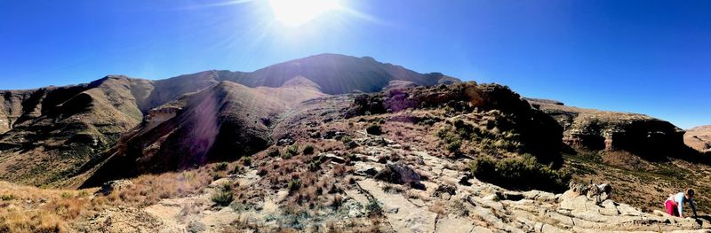 Panoramic view of mountains against sky on sunny day