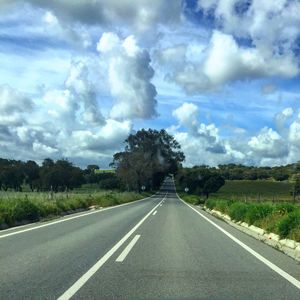 Empty road against cloudy sky