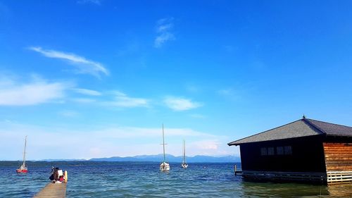 Sailboat by sea against blue sky