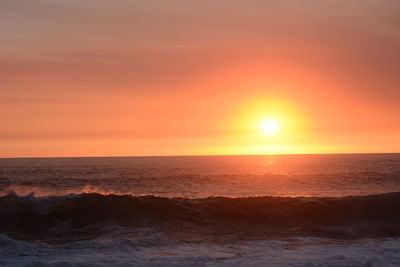 Scenic view of sea against orange sky