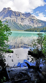 Scenic view of lake by snowcapped mountains against sky