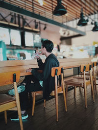 Woman sitting on table in cafe