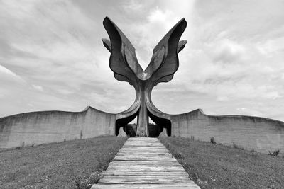 Stone sculpture on land against sky