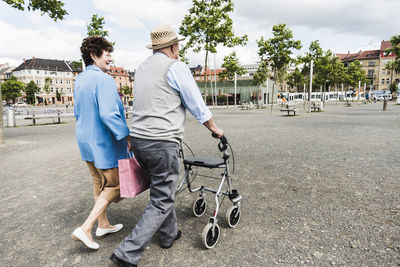 Germany, mannheim, back view of senior couple with wheeled walker