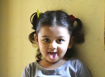 Portrait of cute girl against wall
