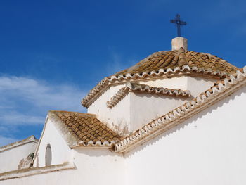 Low angle view of church against blue sky on sunny day