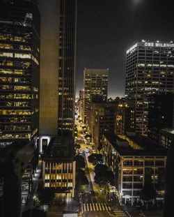 Illuminated buildings in city against sky at night