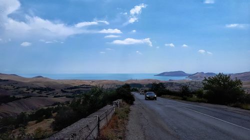 Road by mountain against sky