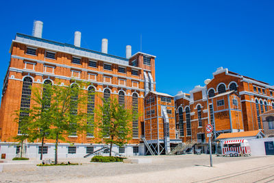 Buildings in city against clear blue sky