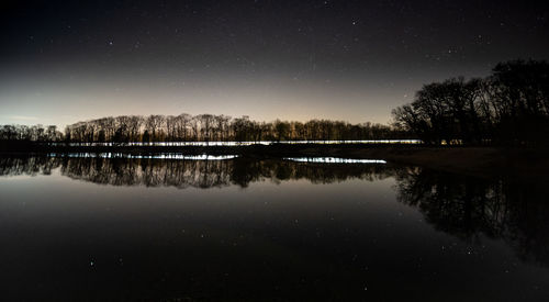 Scenic view of lake against sky at night