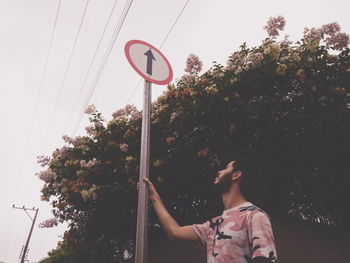 Man with arms raised against trees