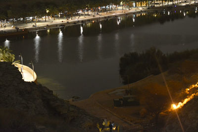High angle view of river by illuminated buildings at night