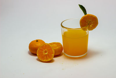 Orange fruit on table against white background