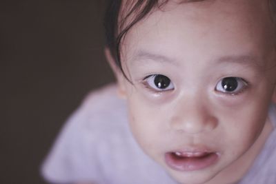 Close-up portrait of cute boy crying at home