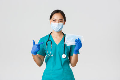 Portrait of teenage girl standing against white background