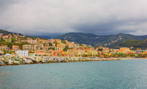 Aerial view of town by sea against sky