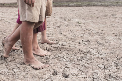 Low section of woman standing on mud