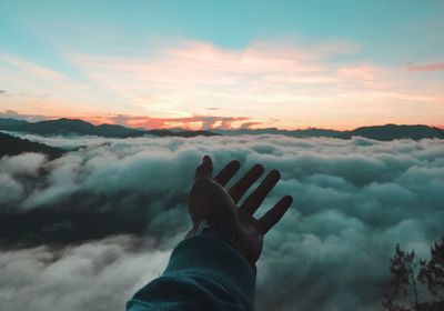 Midsection of person against sky during sunset