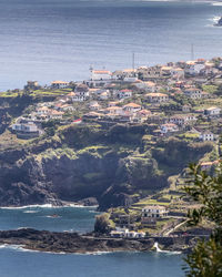 High angle view of houses by sea against sky