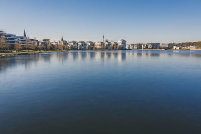 River in city against clear blue sky