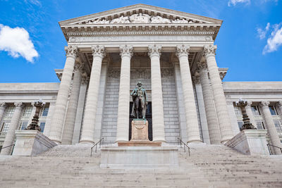 Low angle view of statue of historic building against sky