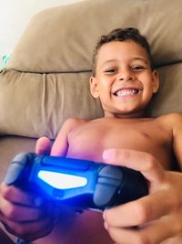 Portrait of happy boy using mobile phone at home