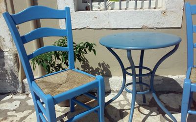 Empty chairs and table at sidewalk cafe