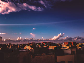 High angle view of buildings in town against blue sky