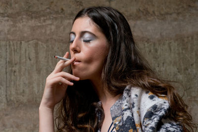 Portrait of a young woman smoking cigarette