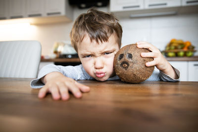 Portrait of cute baby boy sitting on table