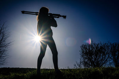 Low angle view of silhouette person standing on field against sky