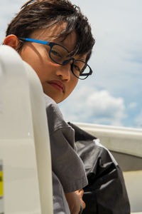 Portrait of boy with eyeglasses against sky