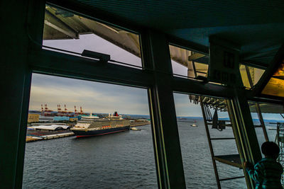 Sailboats in sea seen through window