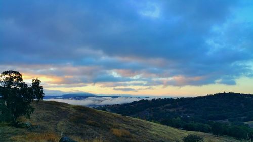 Scenic view of mountains against cloudy sky