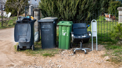 Garbage bin on field against trees