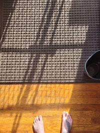 Low section of woman standing on wooden floor