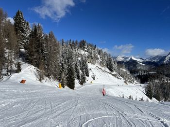 Scenic view of snow covered mountains against blue sky